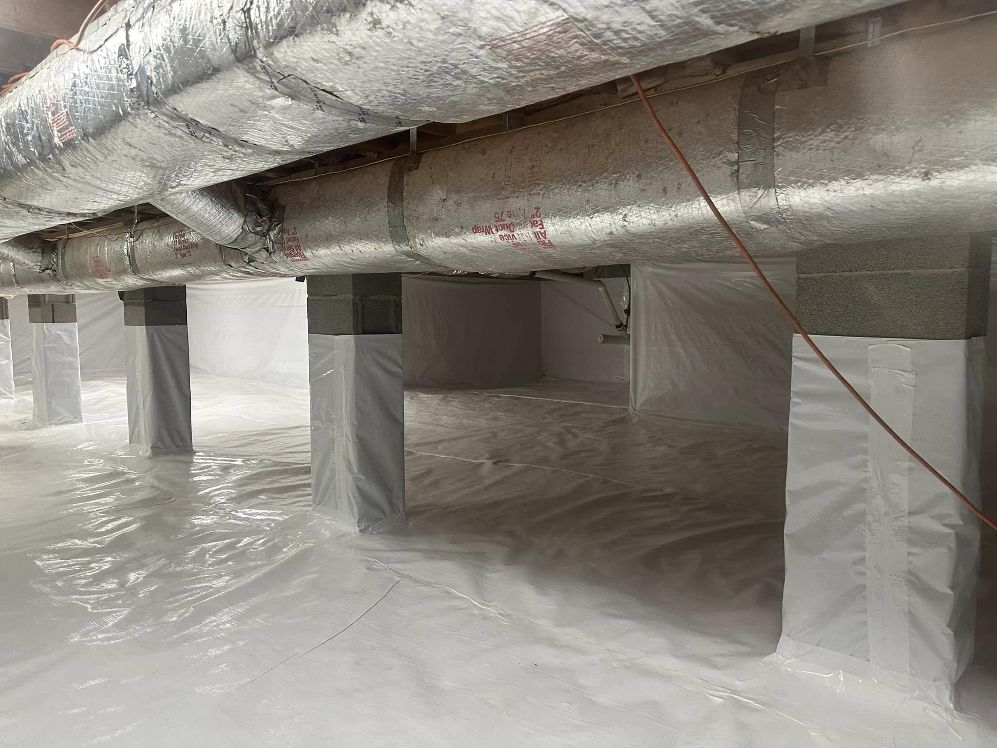 Underside of a home showing floor joists and foundation wall