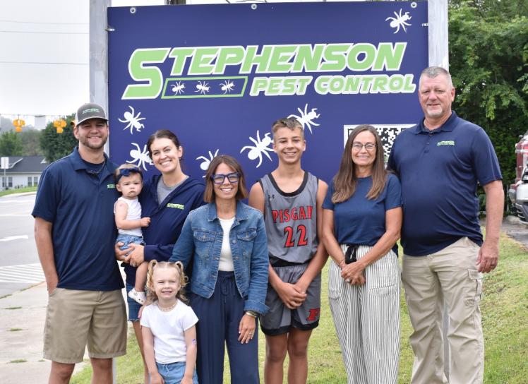 The Stephenson Pest Control family in front of the company sign